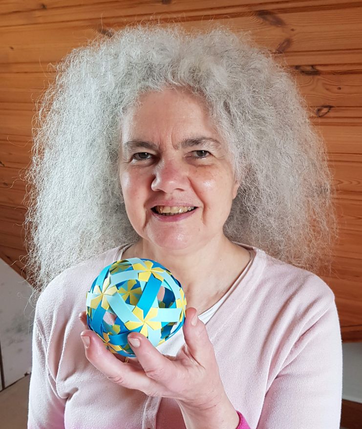 Christiane Bettens holding a modular origami sphere